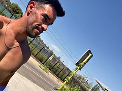 A man with a perfect body naked on a public bench